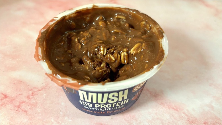 MUSH chocolate brownie overnight oats on pink marble surface