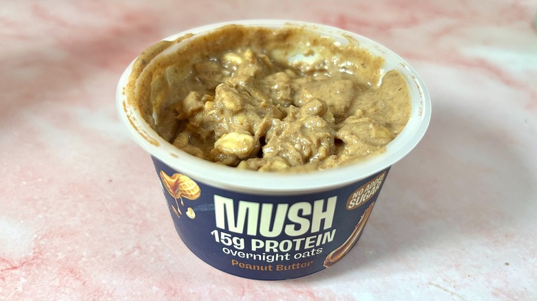 MUSH peanut butter overnight oats on pink marble surface