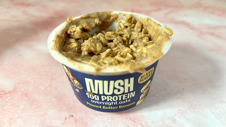 MUSH peanut butter banana overnight oats on pink marble surface