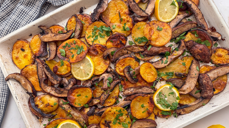 Mushroom potato bake on pan with parsley and lemon slices