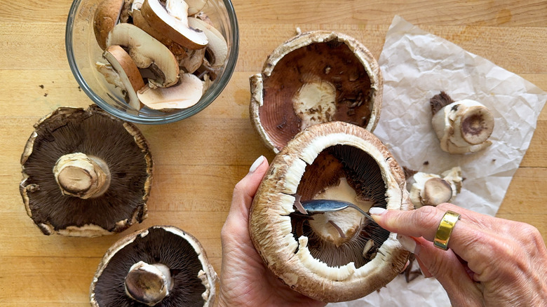 hand removing gills from portobello mushroom