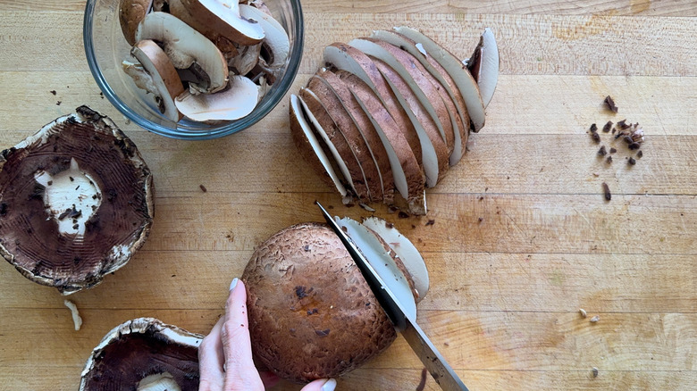 hand slicing portobello mushrooms