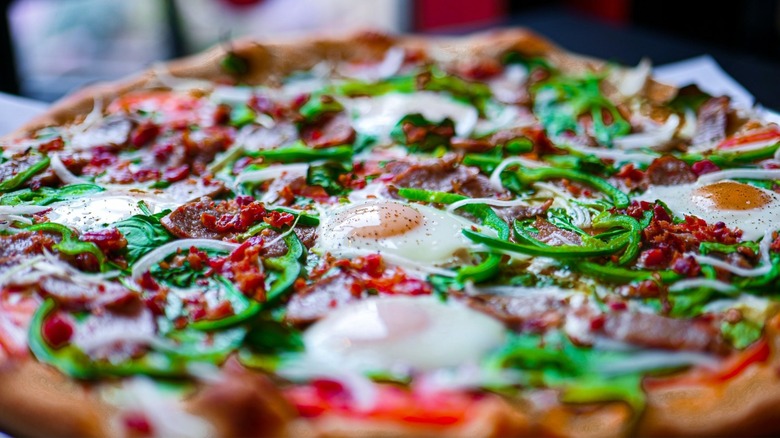 Pizza with peppers and fried eggs