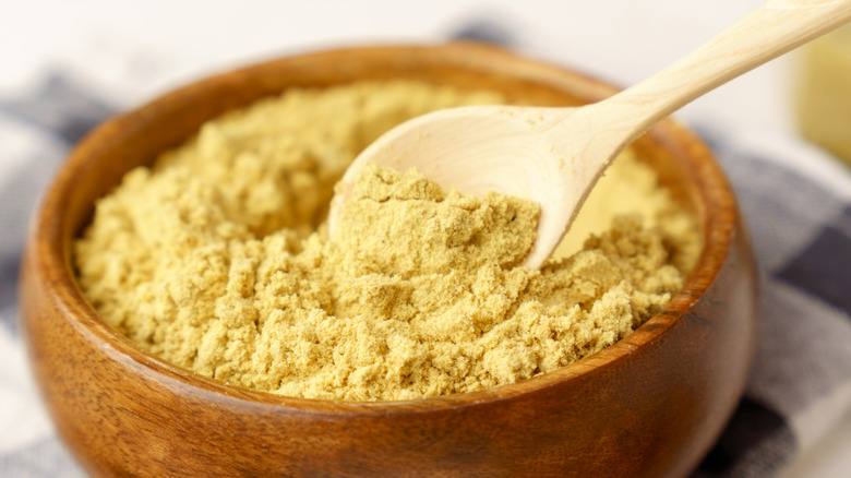 Mustard powder in wooden bowl.