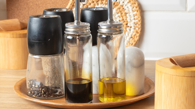 Cruet set with two bottles and three shakers.