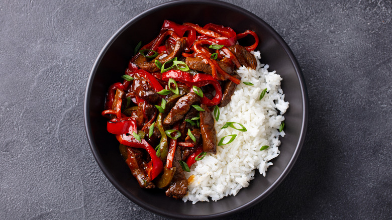 black bowl with beef, peppers and rice