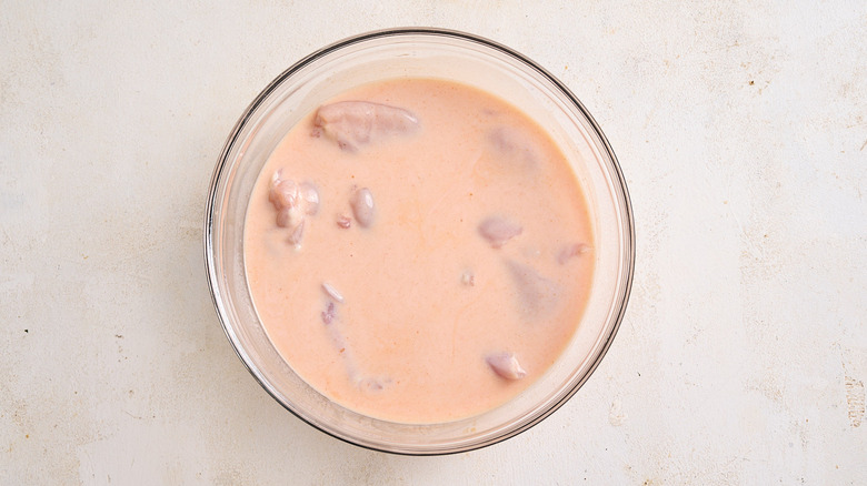 chicken marinating in a bowl