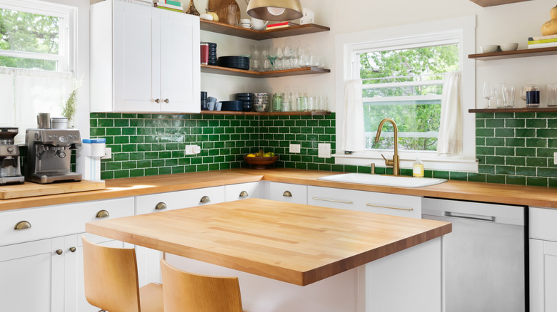 Kitchen featuring butcher block counters and green tile backsplash