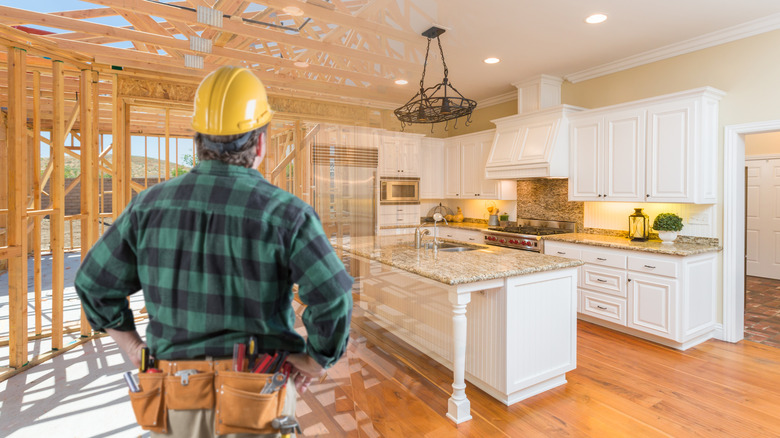 Contractor looking at a newly installed kitchen with white cabinets