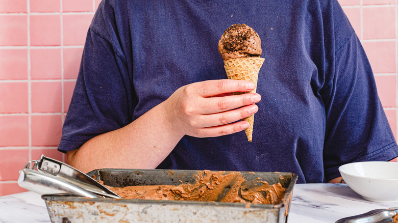 Hand holding a cone of chocolate ice cream