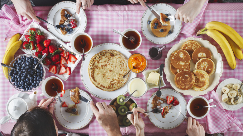 A group of breakfasters seen from above enjoying a variety of brightly colored dishes
