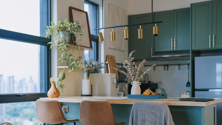 a small kitchen with teal cabinets and island