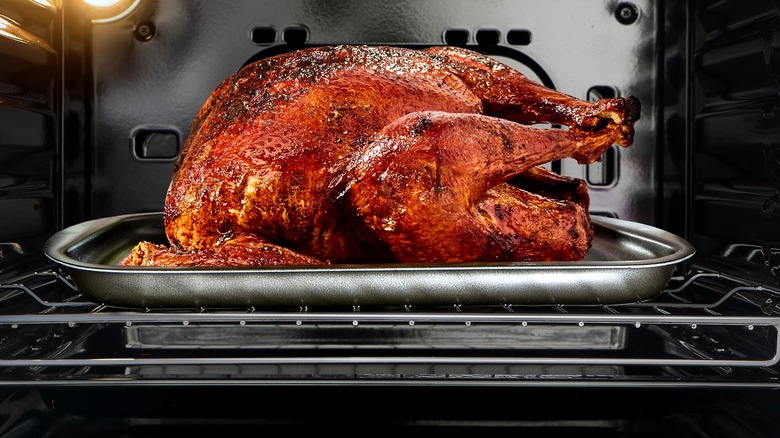 Dark turkey roasting in open oven