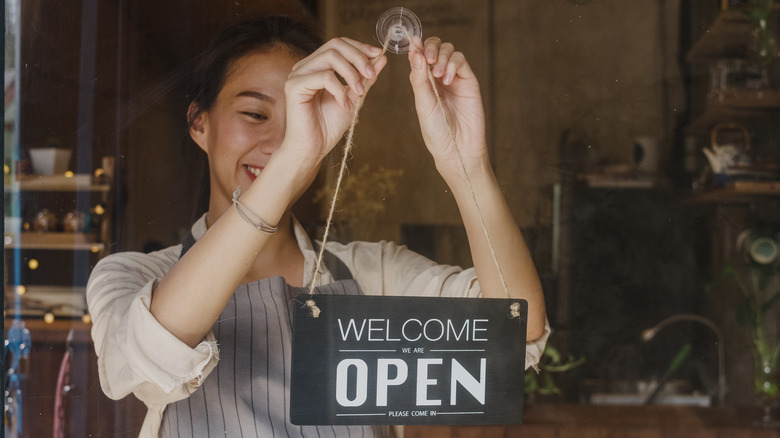 Smiling business owner open sign