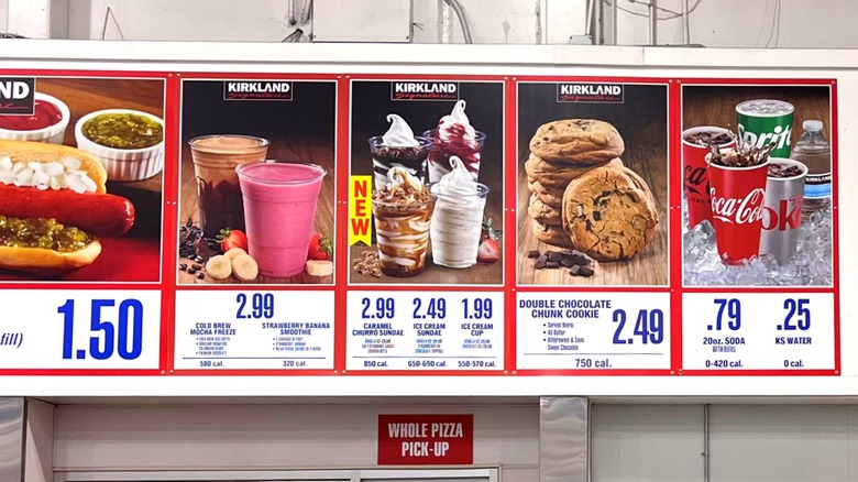 Signboard above Costco food court showing photos and prices of various items including hot dog, smoothies, ice cream sundaes, cookies, and drinks