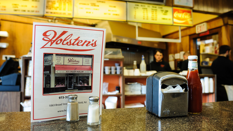 A view from the counter at Holsten's of a menu, napkins, and ketchup