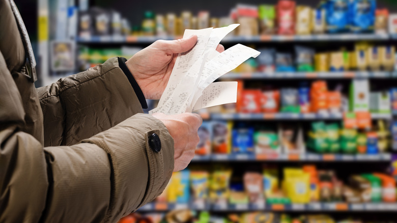 Grocery store shopper holding receipts