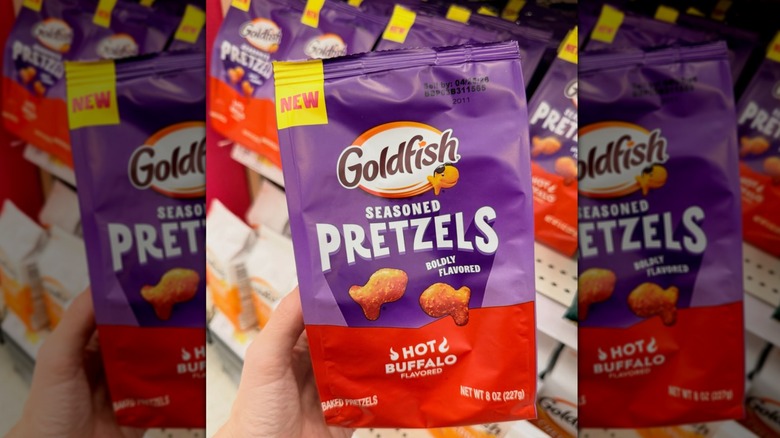Hand holding a bag of Goldfish Hot Buffalo Seasoned Pretzels