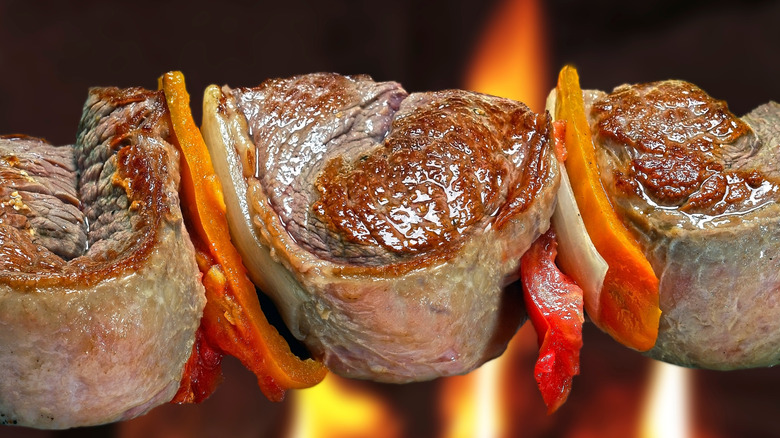 Chunks of roasted lamb meat on a skewer with peppers and onions