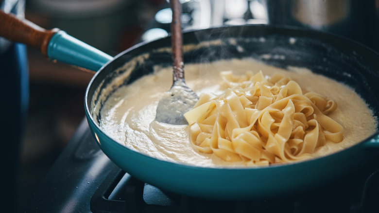 Making chicken Alfredo in pan