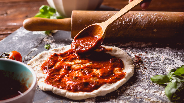 Pizza sauce spread onto a dough
