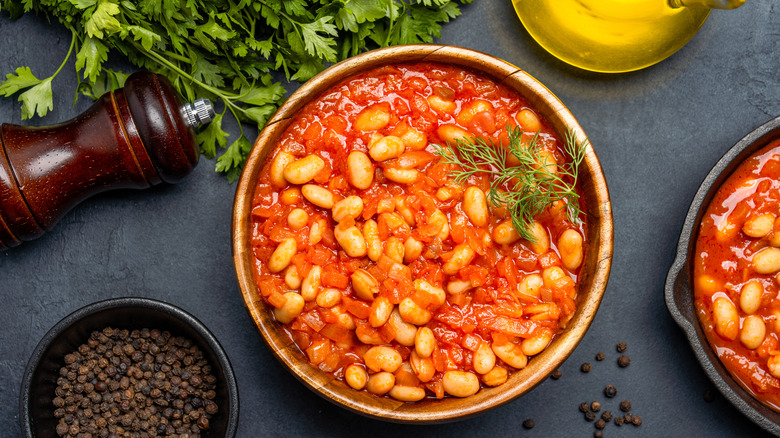 A bowl of baked beans with pepper on the side