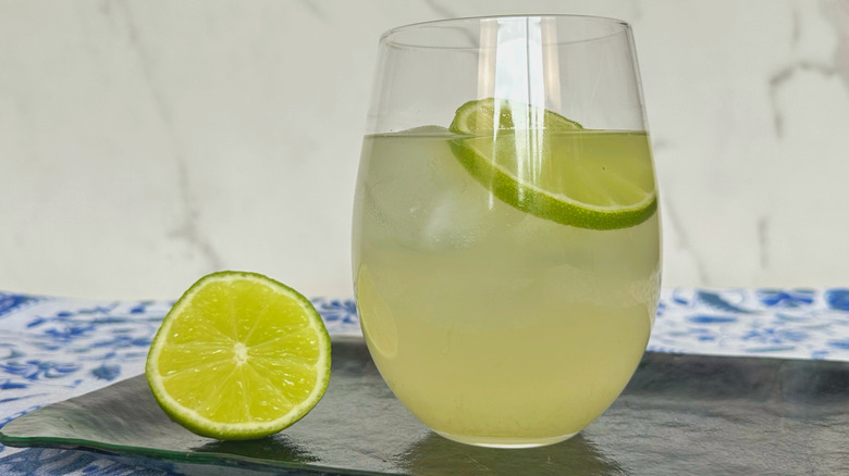 Glass of nimbu pani next to halved lime