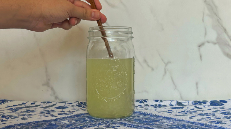 Hand stirring limeade in jar