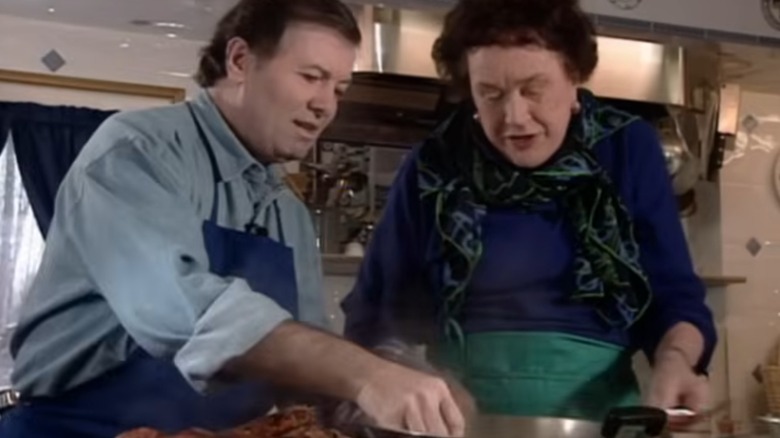 Julia Child and Jacques Pépin standing at a stove cooking lobster