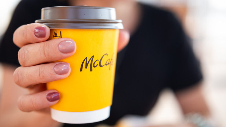 person holding McDonald's McCafe coffee cup