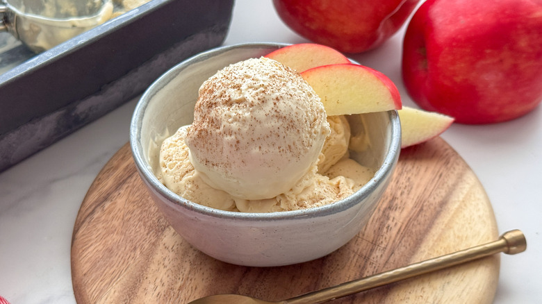 Apple cider ice cream scoops in bowl with apple slices