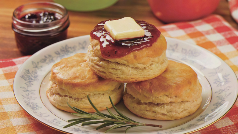 a plate with fluffy biscuits topped with jam and butter