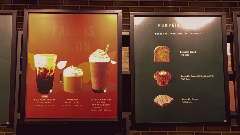 An indoor menu board at Starbucks displaying fall offerings, such as the PSL and pumpkin cold brew