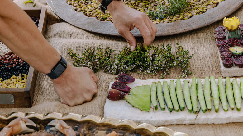 person arranging food on burlap mat