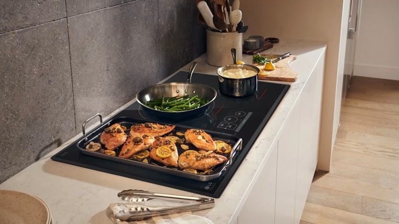 The LG Studio CBIS3618BE induction cooktop with pots and pans heating