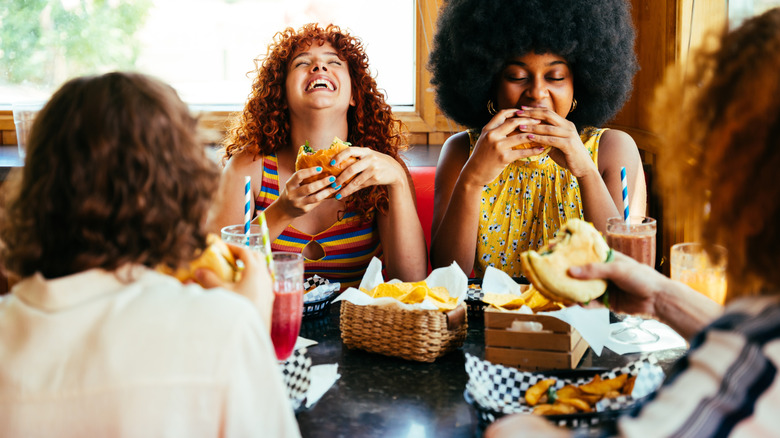 Women laughing and eating hamburgers