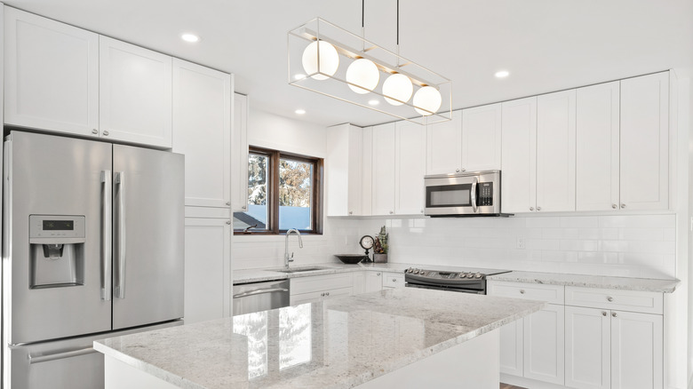 A bright, modern kitchen with white quartz countertops