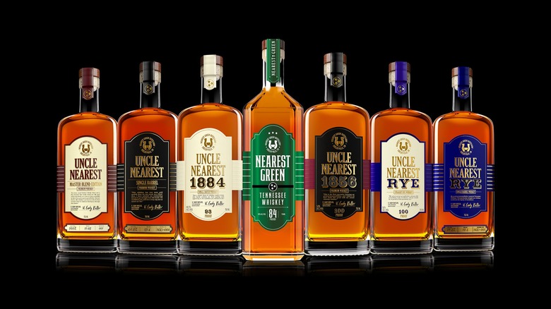 Seven bottles of Uncle Nearest Tennessee whiskey against a black background
