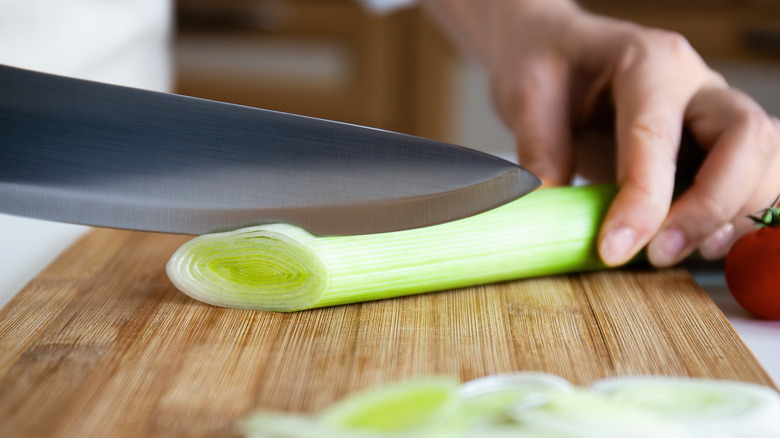 cutting leek on bamboo counter