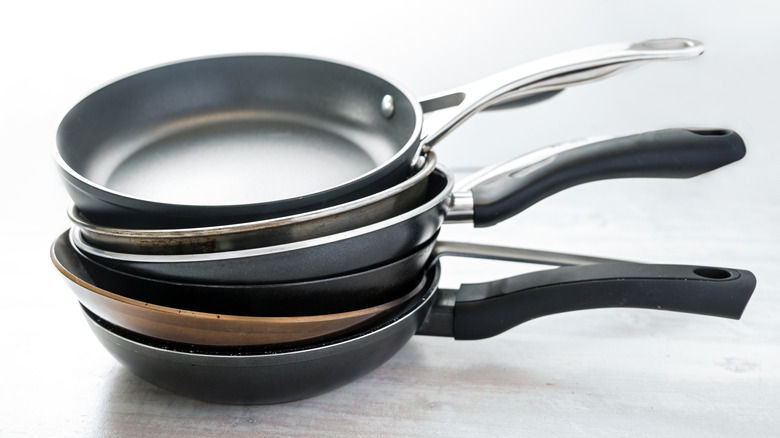 Six non-stick pans stacked on top of each other.