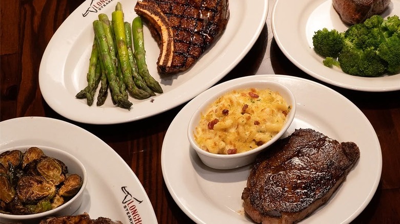 Various sides and steaks on plates at Texas LongHorn Steakhouse
