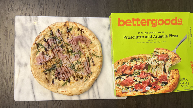 Pizza on cutting board with packaging