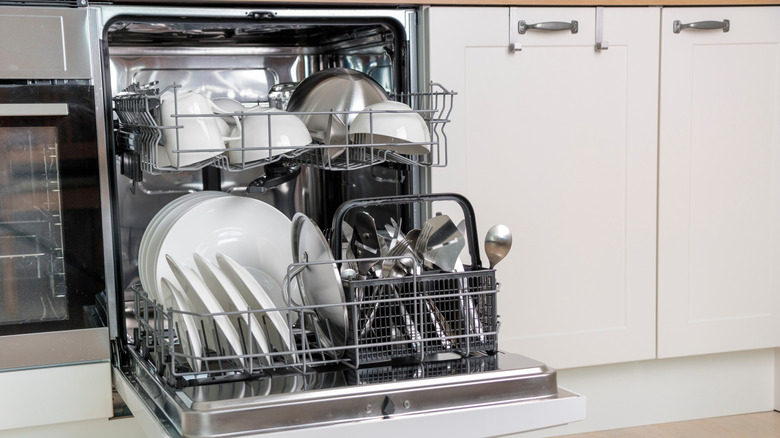 Open dishwasher filled with clean dishes on the two racks