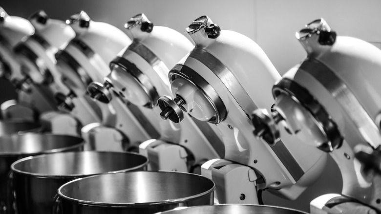 A lineup of white KitchenAid mixers.