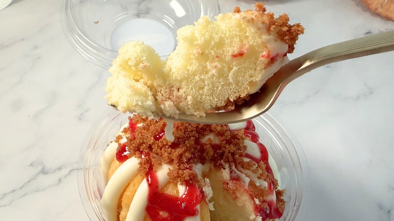 Nothing Bundt Cakes Strawberry Cheesecake Swirl cake piece on fork above bundtlet