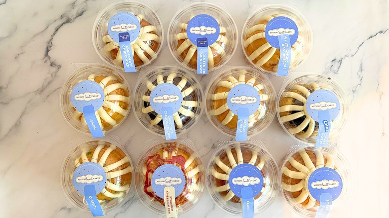 Top-down shot of 12 Nothing Bundt Cake bundtlets in packaging on marble surface