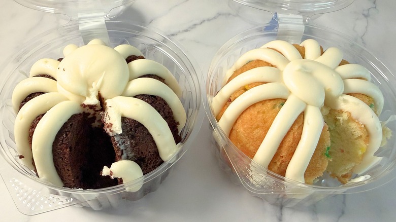Two bundtlets from Nothing Bundt Cakes side-by-side in packaging on marble surface
