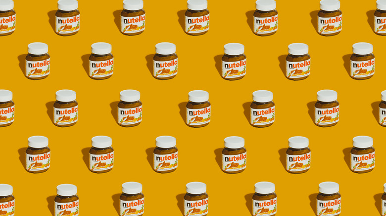 Nutella jars against a mustard yellow background