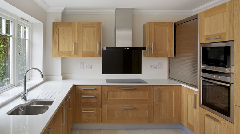 A modern kitchen with a mellow pain color and oak cabinets