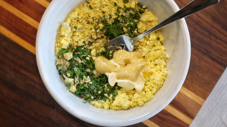 a bowl of mashed boiled egg yolks with parsley, Dijon mustard, and mayonnaise
